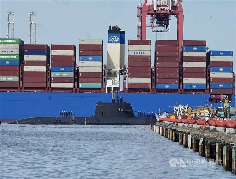 The indigenous defense submarine sails past a container ship at the Port of Kaohsiung on Tuesday. CNA photo June 17, 2025