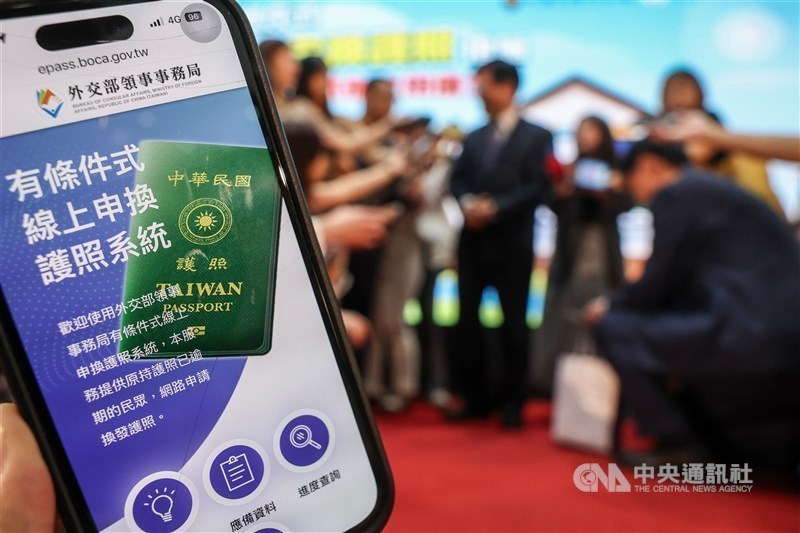 An individual holds a mobile phone displaying the online passport renewal service. CNA file photo
