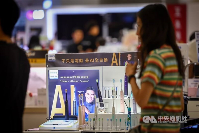 A shopper walks past a booth selling AI-based electric toothbrushes at a department store in New Taipei. CNA file photo