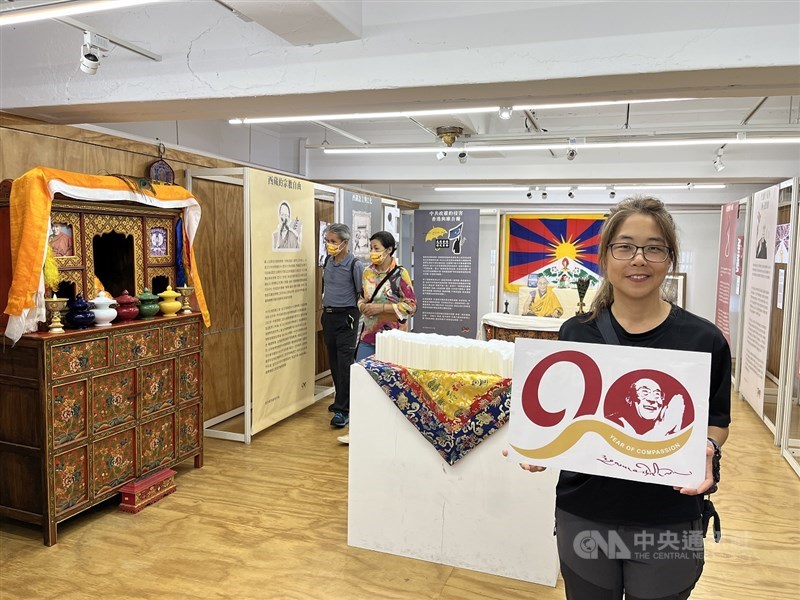 Exhibition visitor Sharon Lai holds a placard wishing the Dalai Lama a happy 90th birthday at a Taipei exhibition on Saturday. CNA photo June 28, 2025