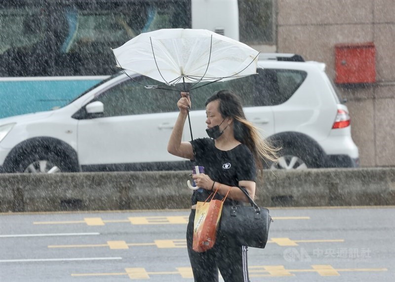 A member of the general public brave the wind and rain in this CNA file photo