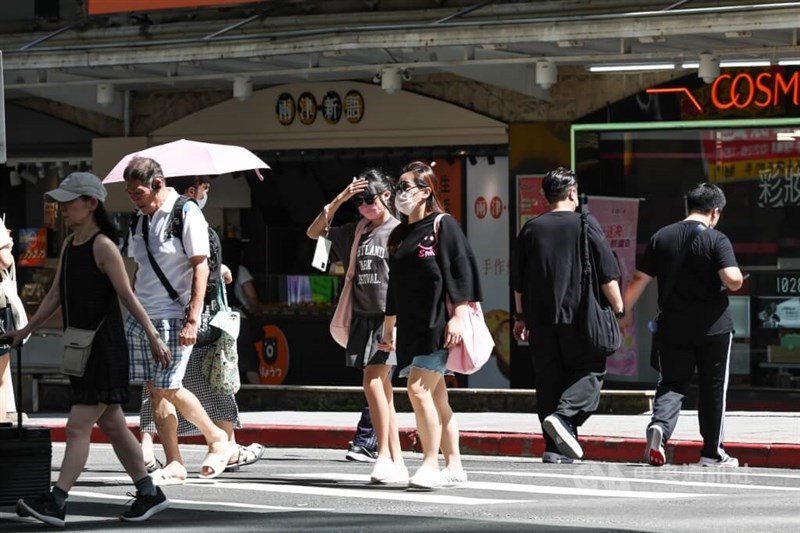 Pedestrians cross a street in Taipei's Neihu District amid hot weather. CNA file photo