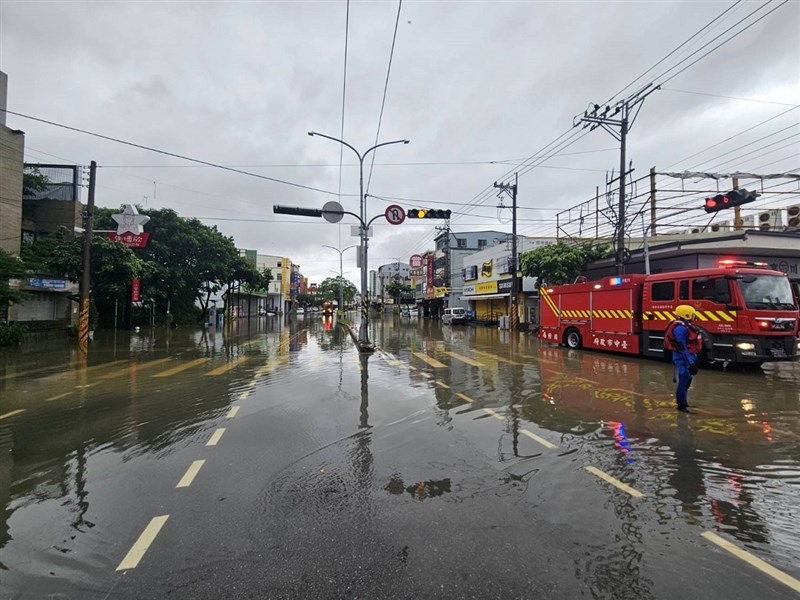 A firefighter stands on a flooded road in Taichung on Monday morning. Photo courtesy of a private contributor