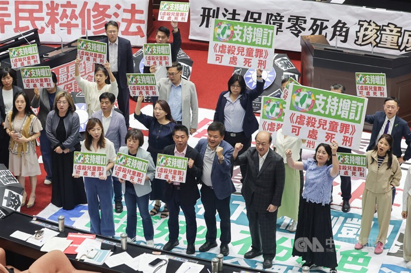 Ruling DPP lawmakers hold signs to deliver their support in amending the nation's Criminal Code to allow the death penalty for those who abuse a child under the age of 7 in a way that results in death. CNA photo July 18, 2025