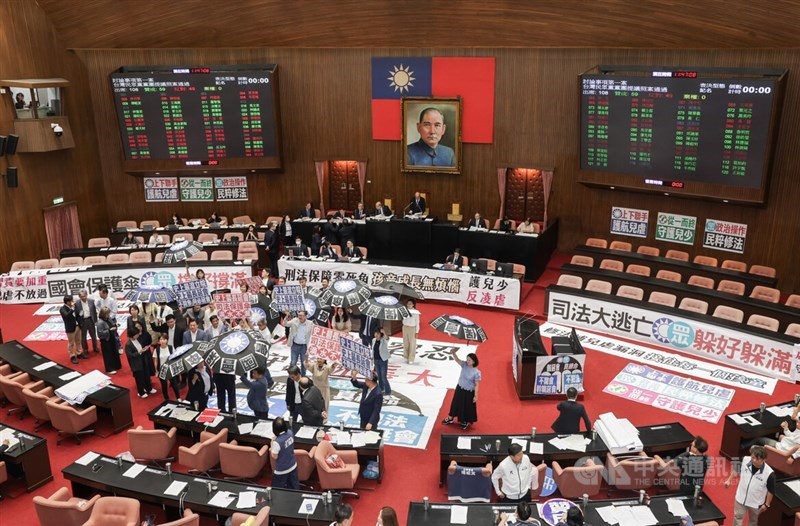 DPP lawmakers hold banners in protest against the extension of the legislative session in Taipei on Friday. CNA photo July 18, 2025