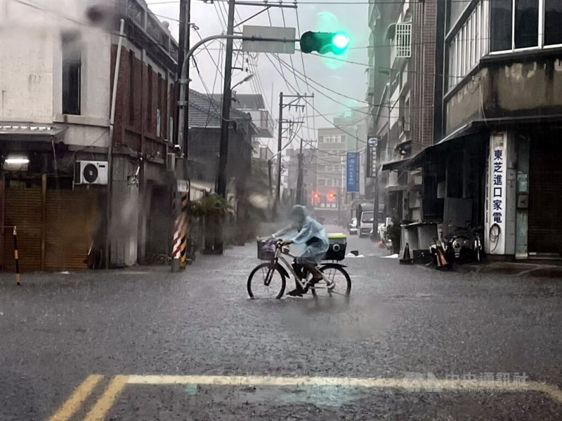A man rides his bicycle through a flooded street in Chiayi County on Monday. Photo courtesy of a private contributor