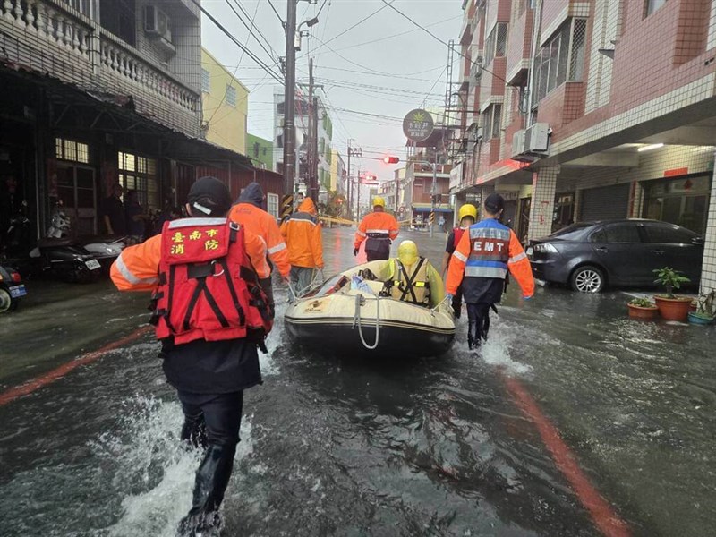 Several firefighters walk through floodwaters during heavy rain in Tainan City on Saturday.Photo courtesy of Tainan City Fire Department Bureau Aug. 2, 2025
