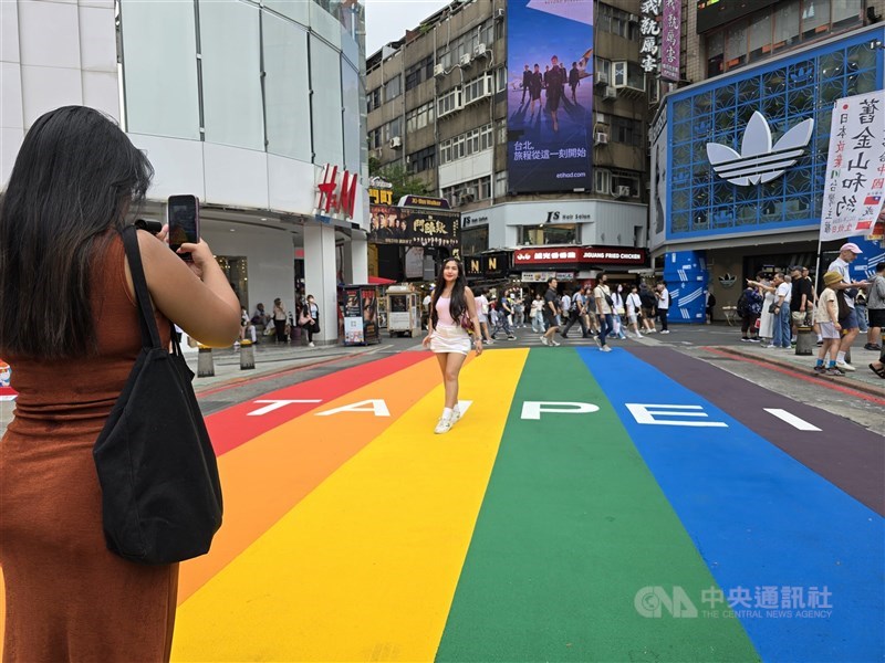 A woman poses with the renewed land art, “Rainbow Six”, in Ximending, Taipei, on Saturday. CNA photo Aug. 9, 2025