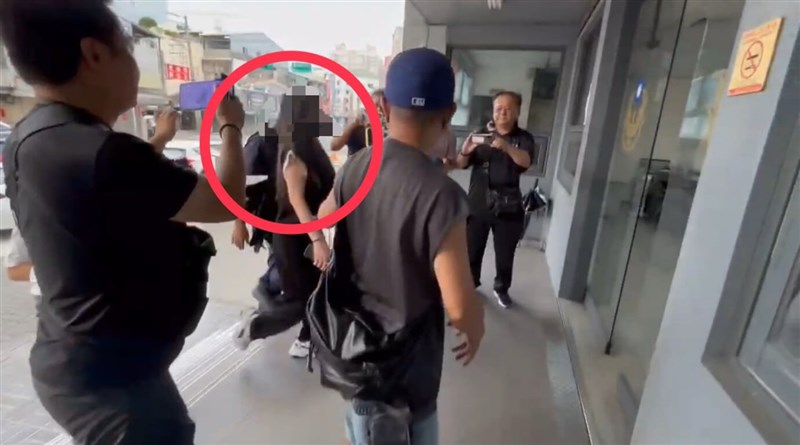 A woman accused of smashing a bottle of wine on a store counter arrives at the police station. Photo courtesy of a private contributor Aug. 10, 2025