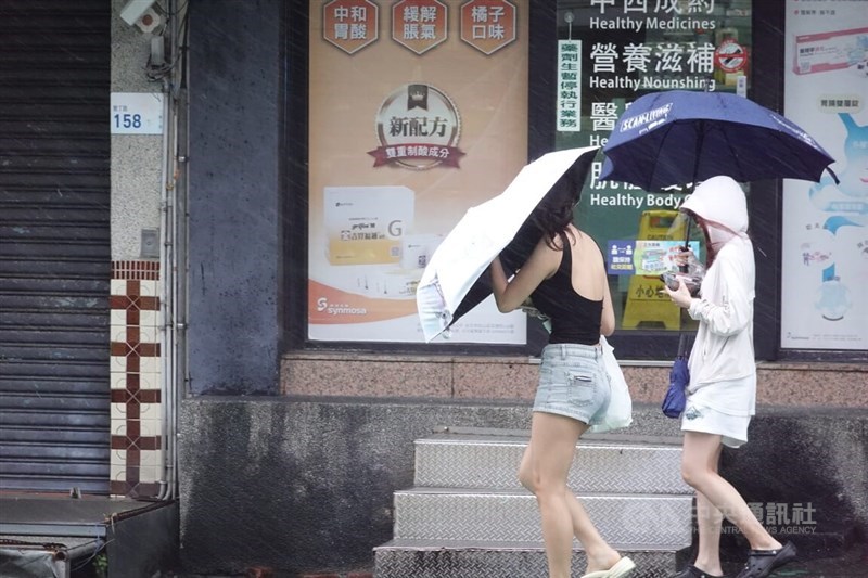 Two people walk in the rain in Kenting, Pingtung County, on Wednesday. CNA photo Aug.13, 2025