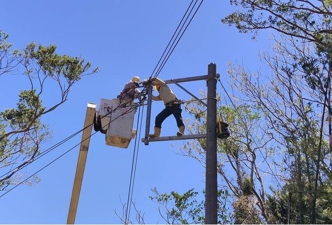 Two Taipower technicians work to retore power in Taitung County in the aftermath of Typhoon Podul. Photo courtesy of Taipower