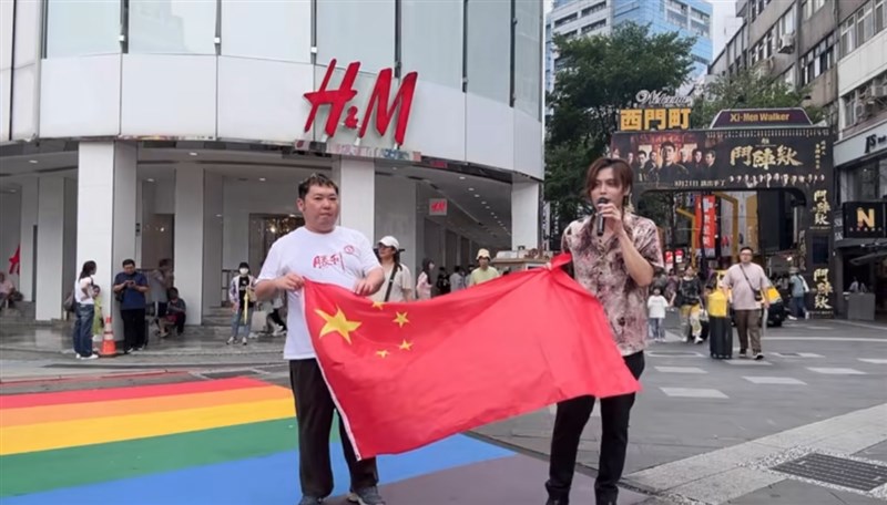 A man who calls himself Aira Todomi (right) on social media and a content creator who calls himself Hiroyuki Tanaka (left) display the flag of the People's Republic of China (PRC) at the famous Ximending LGBTQ Rainbow in Taipei on Aug. 18. Graphic captured from the TikTok of Aira Todomi