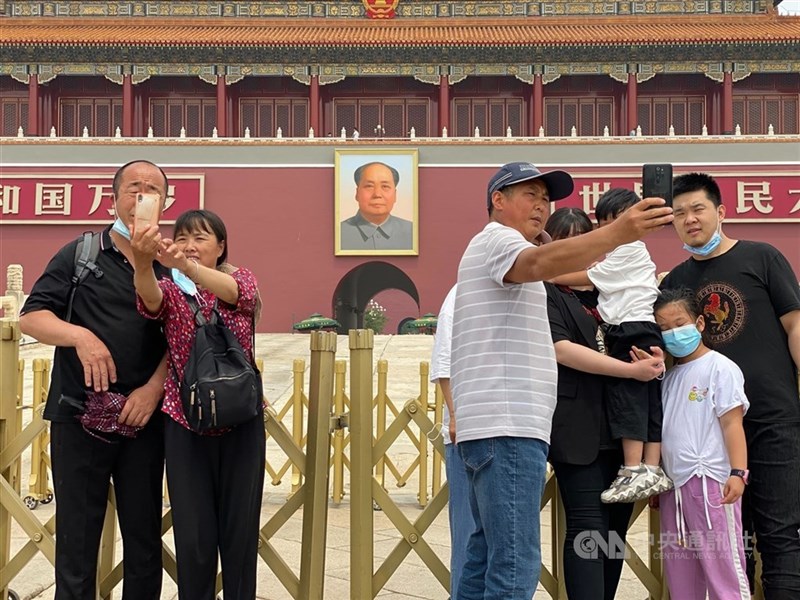 Tourists take pictures together in front of Beijing's Tiananmen Square. CNA file photo