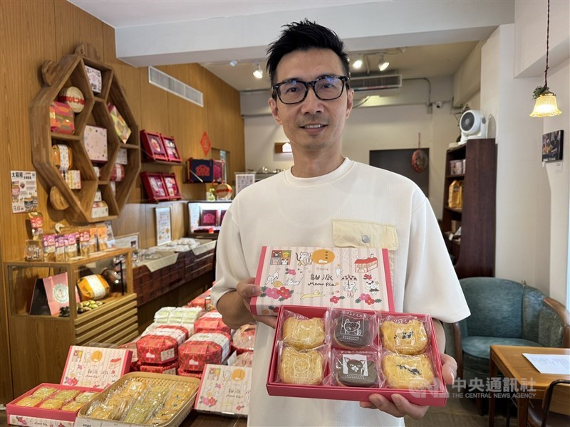 John Lee, president of pastry brand Li Ting Xiang, holds a box of cat-themed products at his store in Dadaocheng in late August. CNA photo Sept. 4, 2025