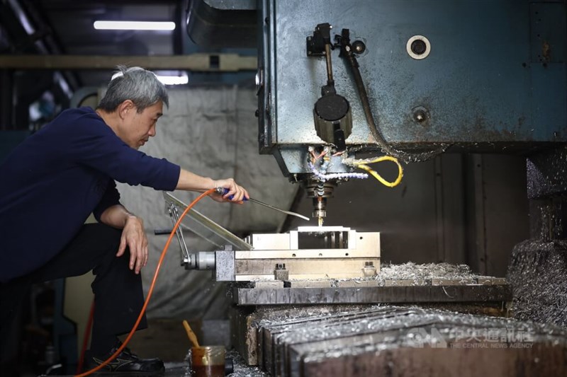 A worker mans a manufacturing line. CNA file photo
