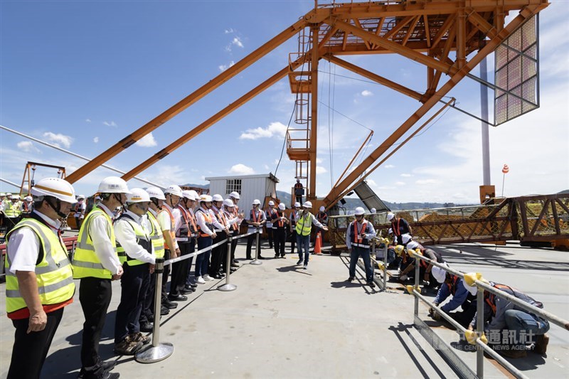 Dignitaries watch the last piece of the Danjiang Bridge being installed on Tuesday. CNA photo Sept. 16, 2025