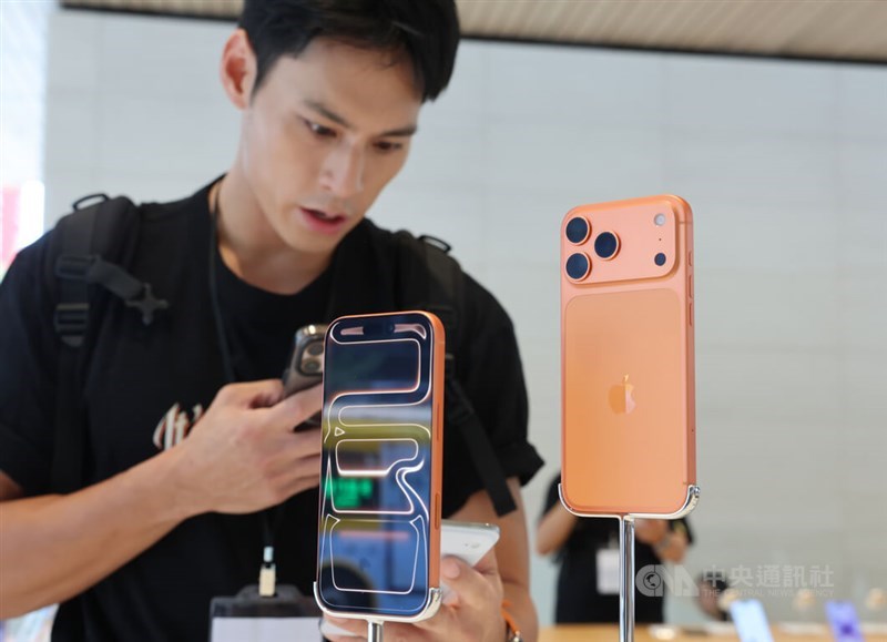 A store visitor examines the newly released Cosmic Orange iPhone 17 Pro at a store in Taipei on Friday. CNA photo Sept. 19, 2025