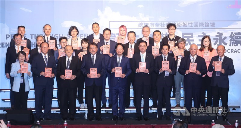 President Lai Ching-te (center front) and government officials held copies of the updated civil defense handbook on Saturday during a forum marking the first anniversary of the Whole-of-Society Defense Resilience Committee under the Presidential Office. CNA photo, Sept. 20, 2025