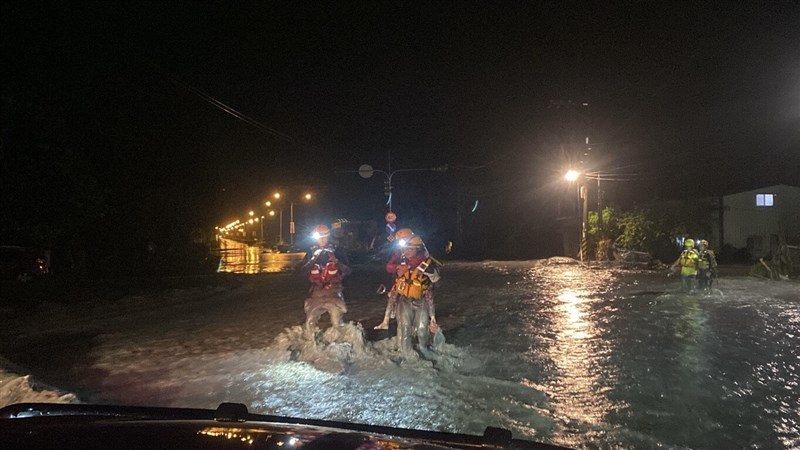 A firefighter (right) carries a flood victim across muddy waters to a shelter Tuesday night in Hualien County's Guangfu Township. Photo courtesy of the Taitung County Fire Department Sept. 24, 2025