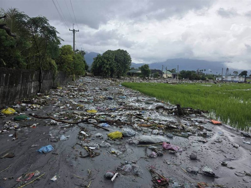 The overflow of the Matai’an Creek landslide lake in Hualien County breaches a downstream levee, sending floodwaters rushing into Guangfu Township and sweeping large amounts of waste from the landfill into nearby villages. Courtesy photo