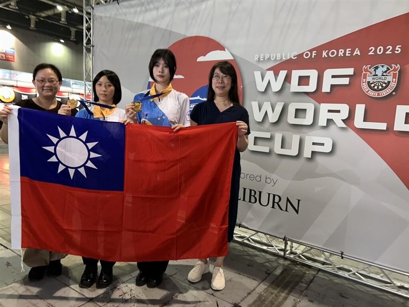 Taiwan's U-18 darts players Tsai Yung-en (second left) and Yang Yi-ching (second right) display the flag of the Republic of China (Taiwan) with their chaperones after winning the 2025 WDF Girl's Best Champions title on Friday. Photo courtesy of the Chinese Taipei Darts Federation