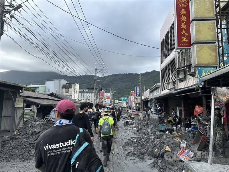 Volunteer traverse through Guangfu Township on Sunday to help clear the mud and debris. CNA photo Sept. 28, 2025