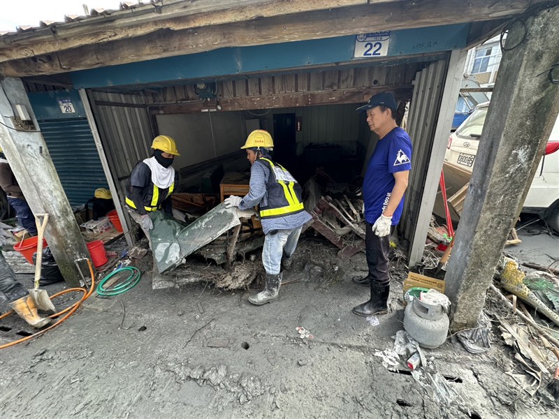 Migrant workers remove debris from the streets Sunday in Guangfu Township, Hualien County. Photo courtesy of Welldoer House