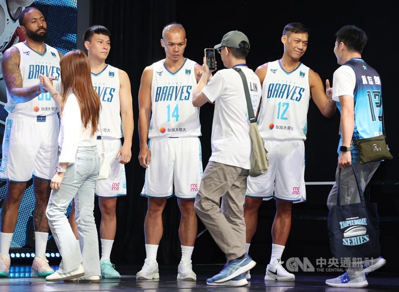 Taipei Fubon Braves shooting guard Lin Chih-chieh (second right) lines up with teammates to fist-bump basketball fans in Taipei on Friday. CNA photo Oct. 3, 2025