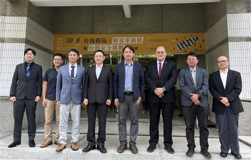 A group of military scholars smile for a photo after a seminar on Chinese military movements at National Chengchi University in Taipei on Wednesday. CNA photo Oct. 8, 2025