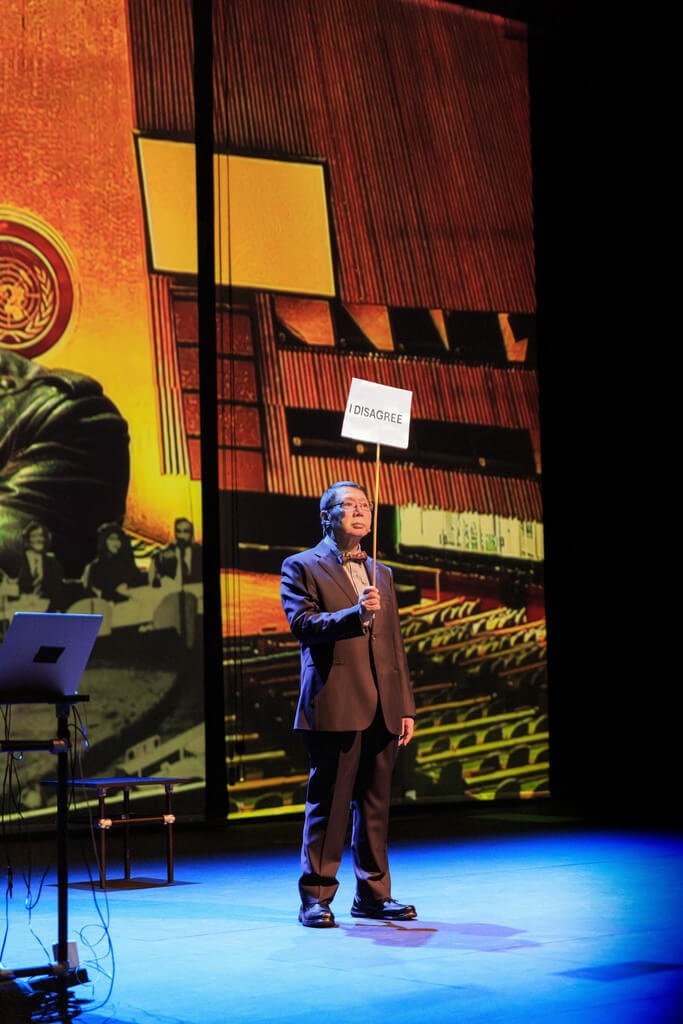 An actor holds up a placard to show his disagreement during the stage play “This Is Not an Embassy (Made in Taiwan)” in Paris, France, on Monday. Photo courtesy of Claudia Ndebele