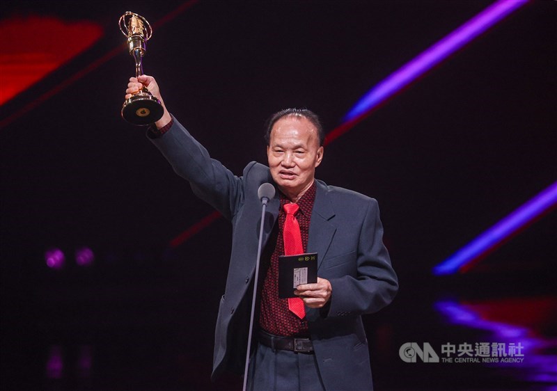 Senior set designer Yeh Hui-lung raises his trophy after receiving the Special Contribution Award in Taipei on Saturday. CNA photo Oct. 18, 2025
