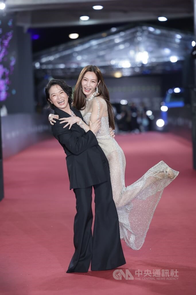 Actress Vicky Tseng (right) playfully hops on actress Hsieh Chiung-nuan to show off their friendship on the red carpet in Taipei on Saturday. CNA photo Oct. 18, 2025