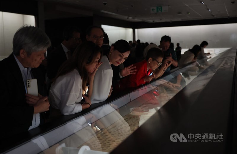 Visitors to the National Palace Museum lean toward shelves displaying relics in the exhibition "An Assembly for the Ages: The Legend of the Northern Song Elegant Gathering in the Western Garden" in Taipei on Tuesday. CNA photo Oct. 21, 2025