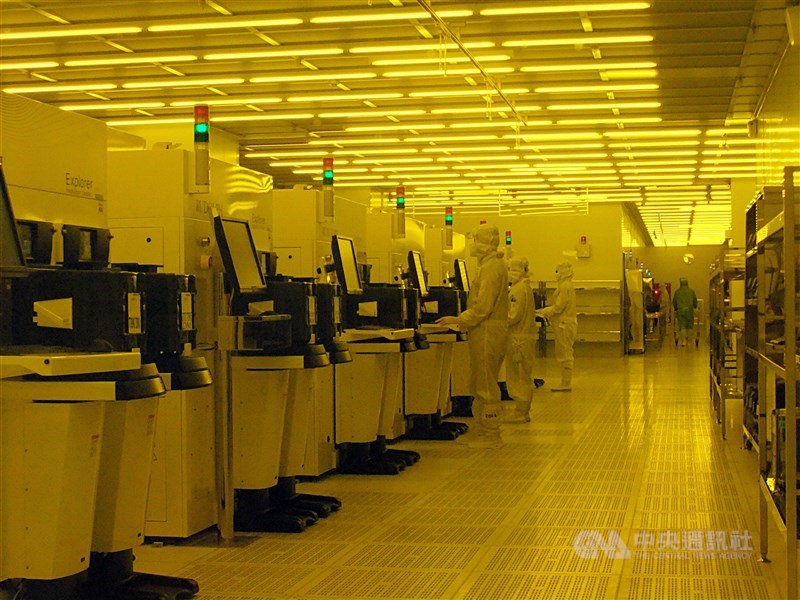 Technicians operate equipment inside a clean room at a semiconductor fab in Taiwan. CNA file photo
