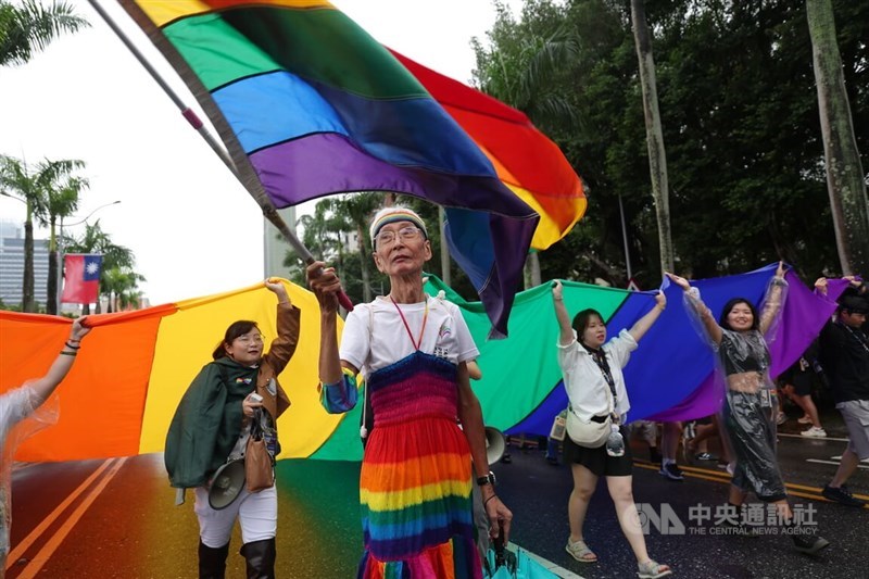 LGBTQ rights activist Chi Chia-wei (second left), dressed in rainbow colors, waves a flag while leading the 23rd Taiwan Pride parade in Taipei on Saturday. CNA photo Oct. 25, 2025