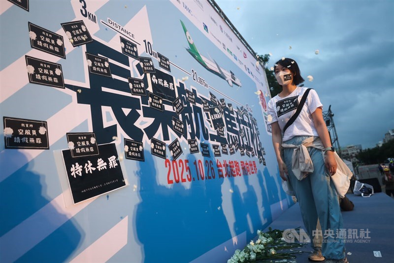 A TFAU member observes the placards her union attached to the marathon publicity banner on Sunday that spells out the union's demands. CNA photo Oct. 26, 2025