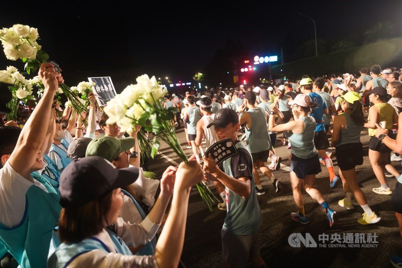 Holding white roses, TFAU members on Sunday urge Taiwan's EVA Airways to make a concrete commitment not to penalize employees in their performance evaluations for taking sick leave during the airline's annual marathon event. CNA photo Oct. 26, 2025