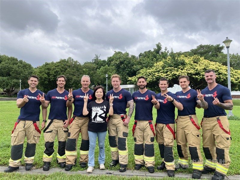 Rose Huang (fourth left), founder of Dog Home Taiwan, poses with Australian firefighters at Taipei Expo Park Monday. CNA photo Oct. 27, 2025
