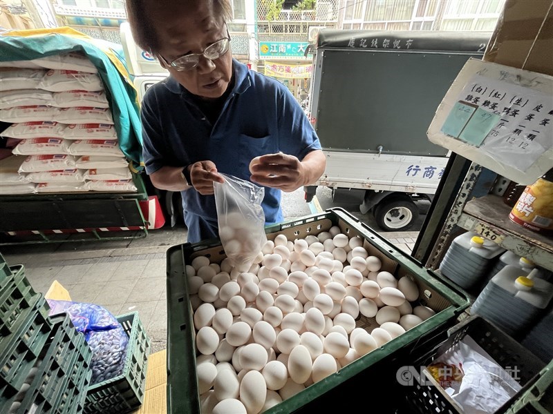 A customer selects eggs at a traditional grain and produce shop in Taipei’s Beitou District on Monday. CNA photo Nov. 10, 2025