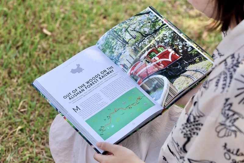 A person flips through a Lonely Planet guide featuring the Alishan Forest Railway. Photo courtesy of the Alishan National Forest Recreation Area