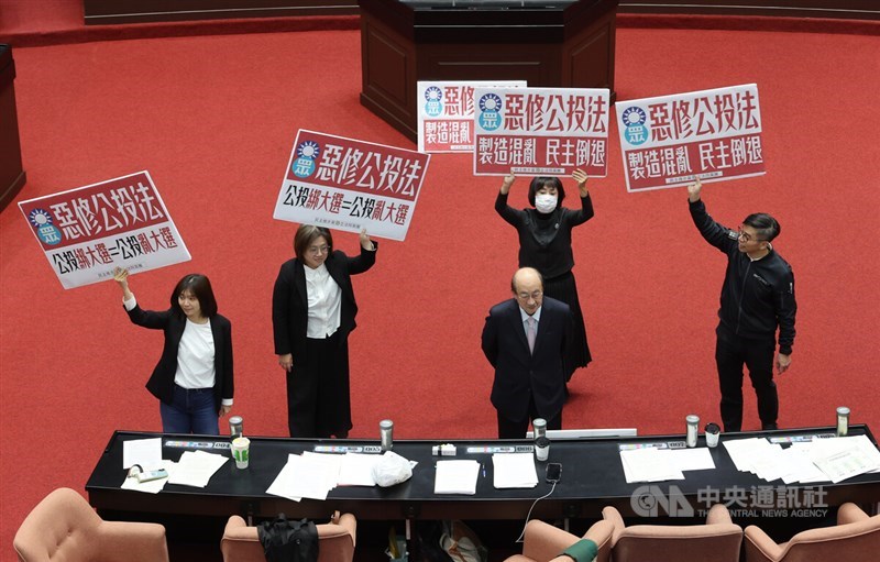 Legislators hold placards at the Legislative Yuan in Taipei on Friday. CNA photo Nov. 21, 2025