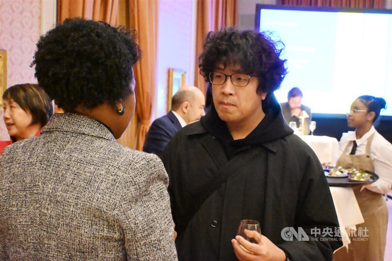 Puma Shen speaks with an attendee at the event. CNA photo Nov. 21, 2025.