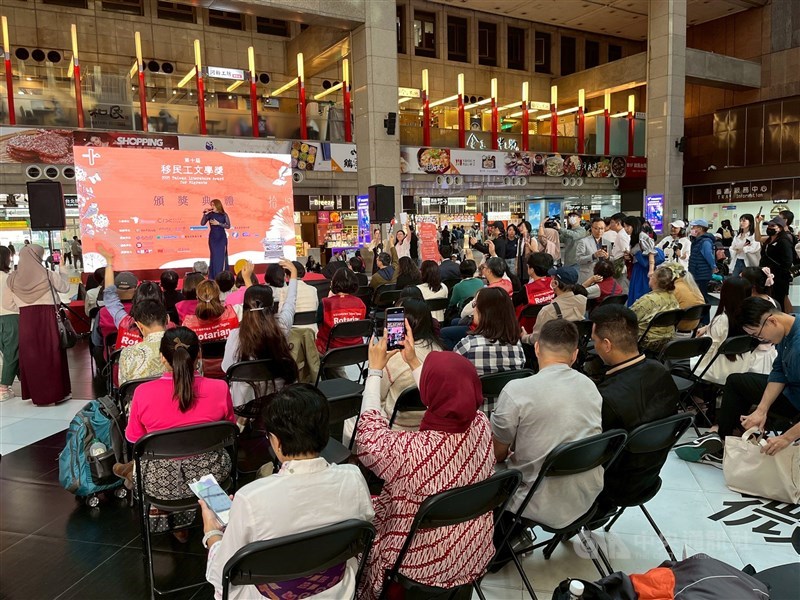 An opening performance by an Indonesian singer draws a crowd, many of them migrant workers, at the ceremony at Taipei Main Station on Sunday. CNA photo Nov. 23, 2025