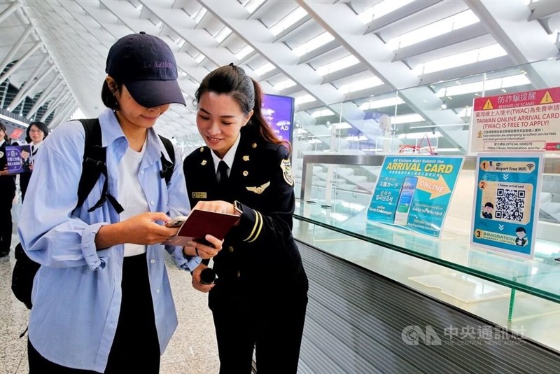 An immigration officer explains the online Taiwan Arrival Card to a foreign national in the Taoyuan Airport. CNA file photo