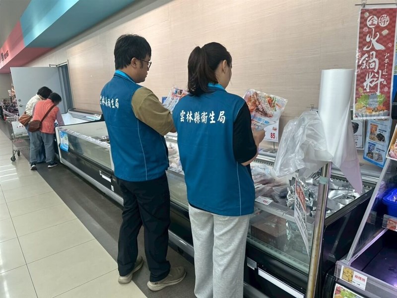 Two officials from the Yunlin County Health Bureau examines a packet of tilapia fillets produced in the county. Photo courtesy of the Yunlin County Government