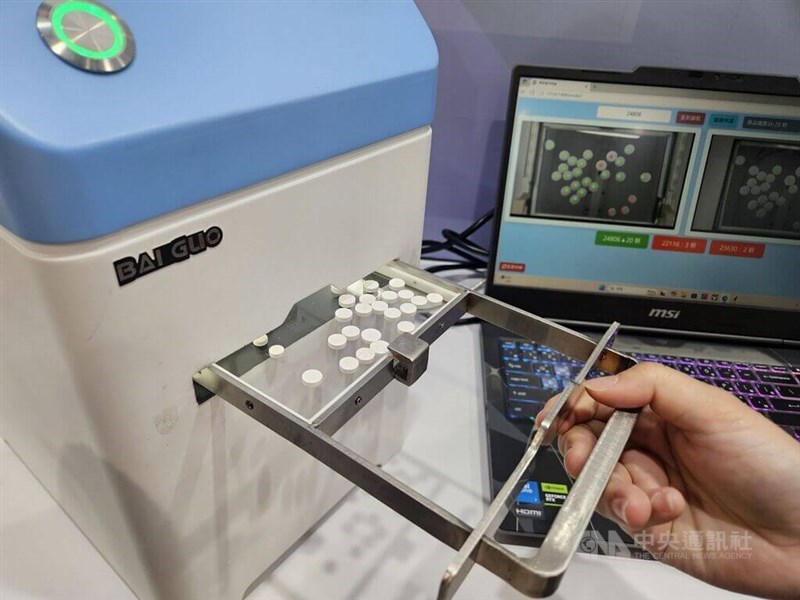Medicine pills are processed through a machine in this CNA file photo