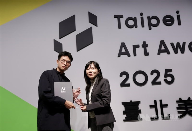 Hsieh wei (left) receives the Grand Prize on the Taipei Art Award 2025 prize ceremony at the Taipei Fine Arts Museum on Friday. CNA photo Dec. 12, 2025
