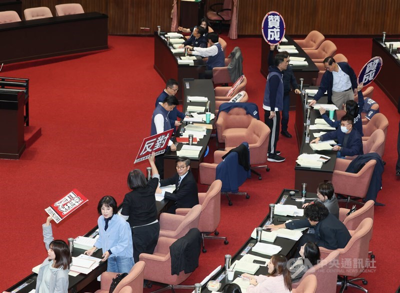Taiwanese lawmakers hold up “agree” and “disagree” cards during a vote on extending the current Legislative Yuan session until Jan. 31, 2026, at the Legislative Yuan in Taipei on Friday. CNA photo Dec. 19, 2025