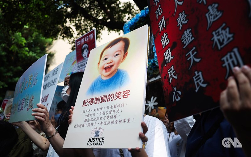 People hold placards supporting a young boy “Kai Kai” outside the Taipei District Court in Taipei on May 13. CNA file photo