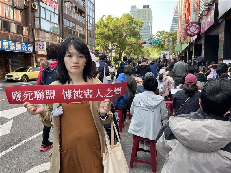 Bella Chang, five months pregnant, holds a placard criticizing the Taiwan Alliance to End the Death Penalty at a march in Taipei on Sunday. CNA photo Jan. 11, 2026